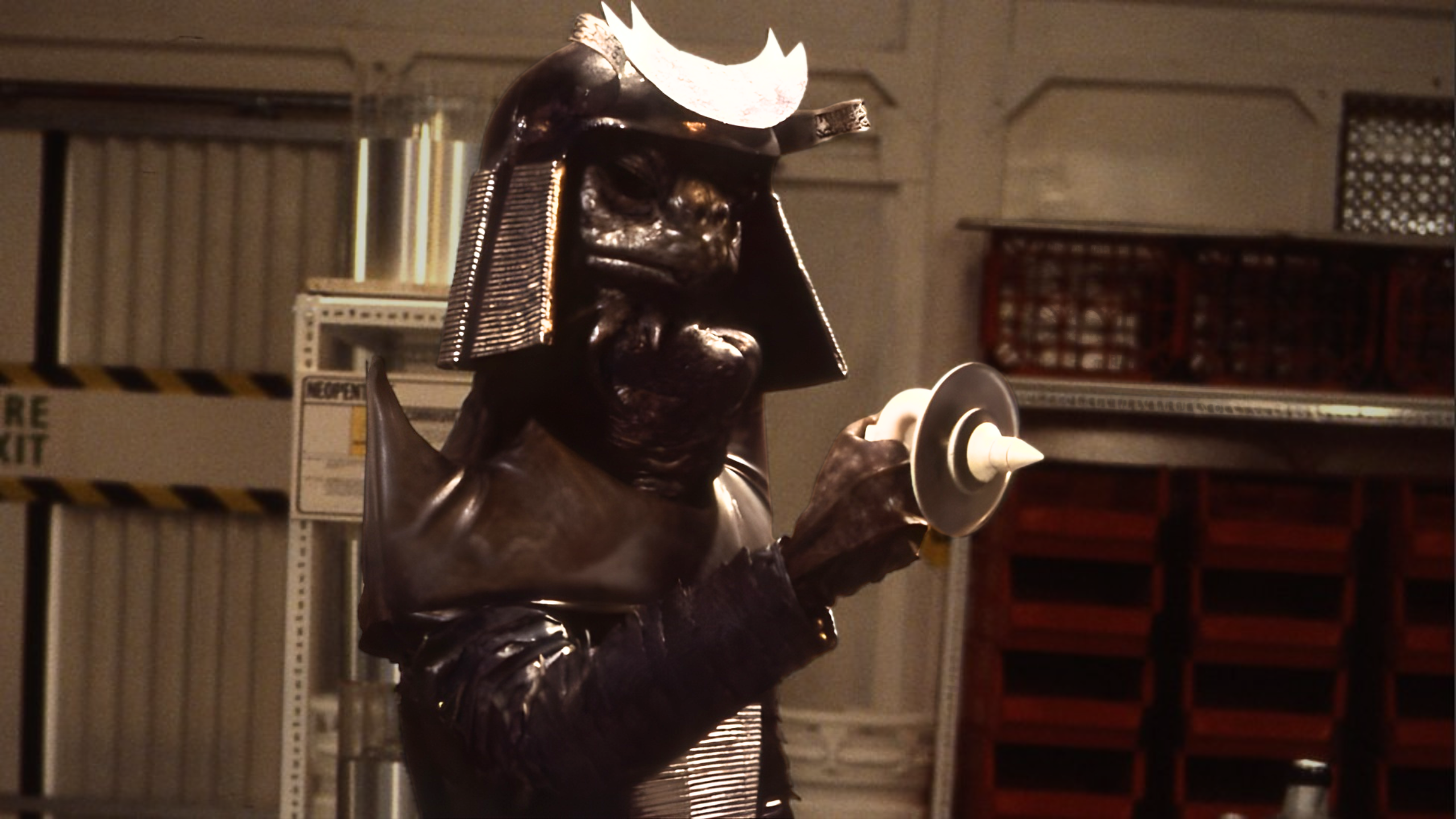 Warriors of the Deep Sea Devil(1) In Warriors of the Deep, Sea Devils attempt to trigger a nuclear war between human factions. (c) BBC Studios. A Sea Devil in samurai type armour holds up a distinctive dish shaped ray gun in a futuristic looking base.